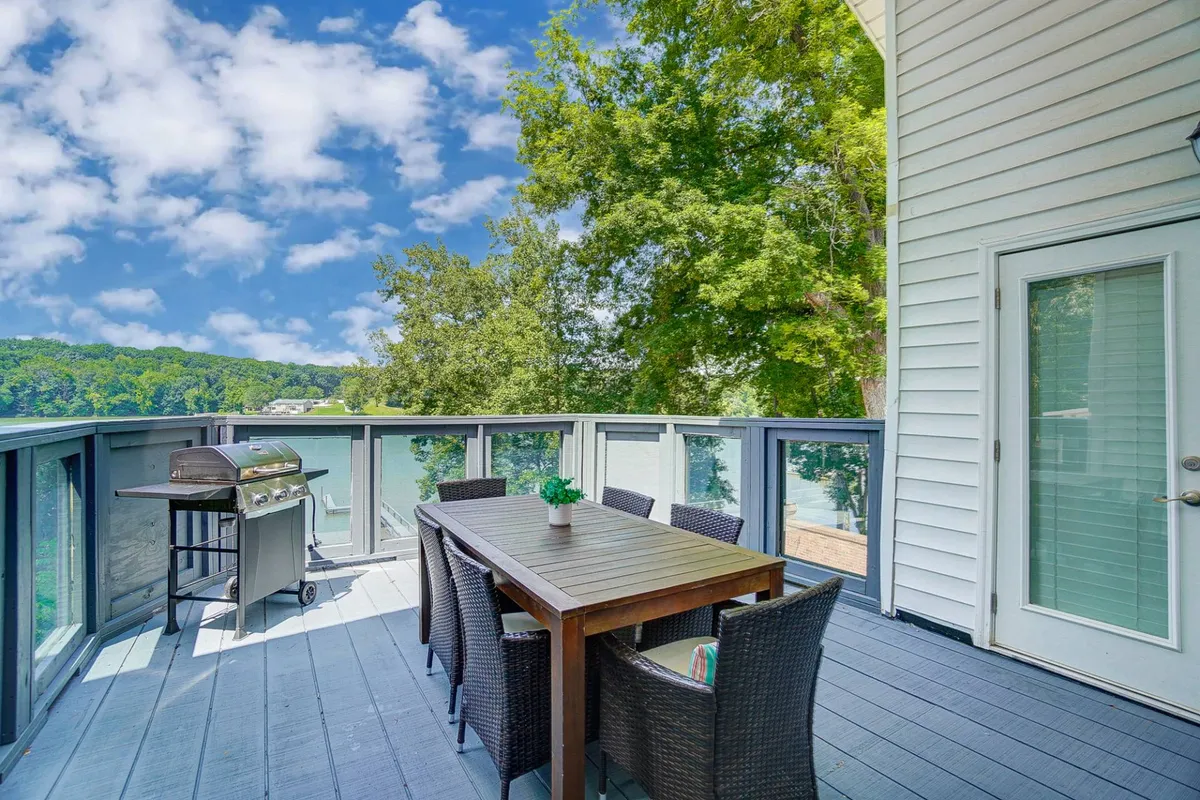 The hero image showcases a spacious outdoor dining area overlooking the tranquil Catawba River, featuring a large table set for gatherings, a grill ready for barbecues, and lush natural scenery providing a peaceful backdrop.